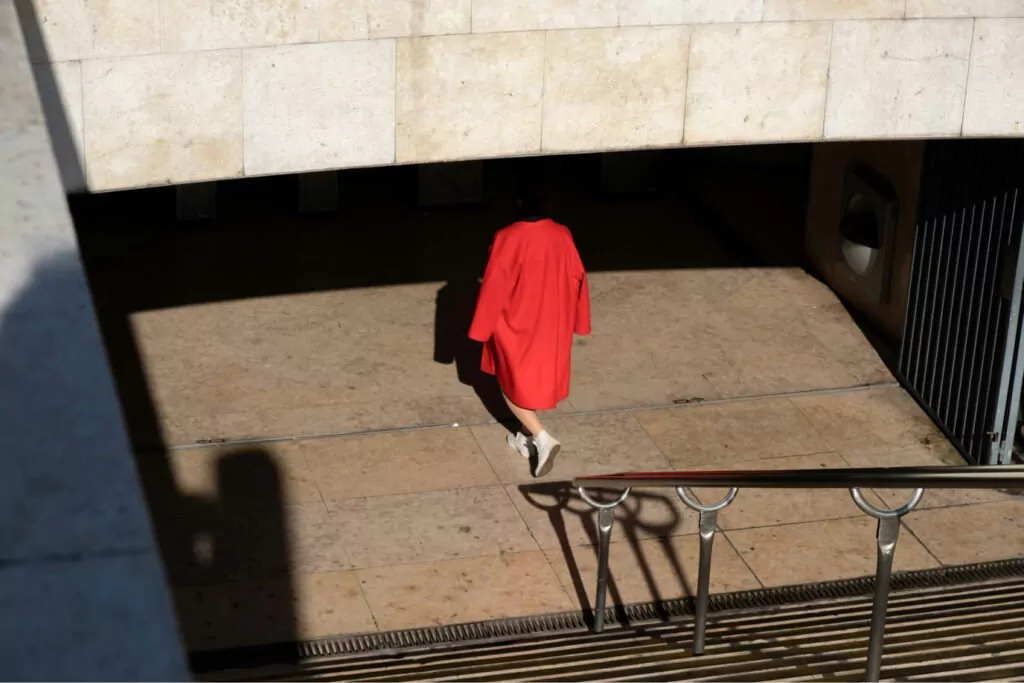 A photograph of a lady where she appears headless because of the shadow.